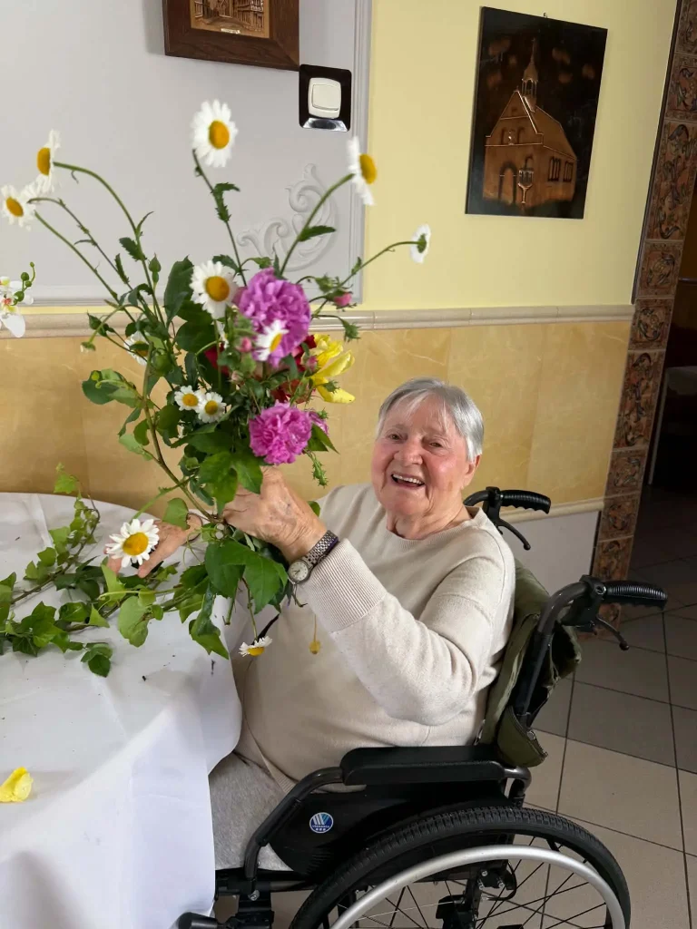 Seniorka trzyma bukiet kwiatów